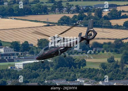 Ein schwarzer Hubschrauber, der über die Gebäude fliegt und auf die Stadt gerichtet ist, die Bray Air Display Air Show Stockfoto