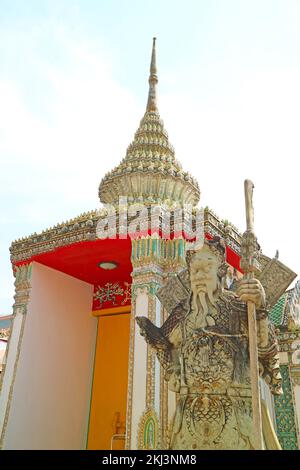 Die Statue des chinesischen Wächters diente vor Jahrhunderten einst als Ballaststein auf den Schiffen neben dem kunstvoll verzierten Eingang zum Wat Pho Tempel in Bangkok, Thailand Stockfoto