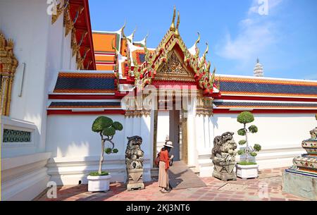 Weibliche Besucher am wunderschönen Innentor des Tempels des liegenden Buddha oder Wat Pho, einem der ältesten buddhistischen Tempel in Bangkok, Thailand Stockfoto