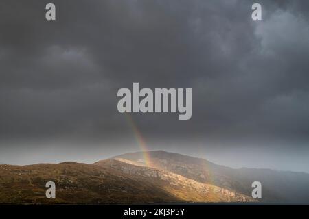 Ein nasses, herbstliches HDR-Bild eines doppelten Regenbogens über der Sutherland-Landschaft bei Unapool in den schottischen Highlands. 26. Oktober 2022 Stockfoto
