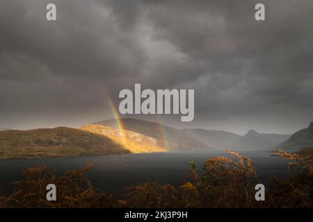 Ein nasses, herbstliches HDR-Bild eines doppelten Regenbogens über der Sutherland-Landschaft bei Unapool in den schottischen Highlands. 26. Oktober 2022 Stockfoto