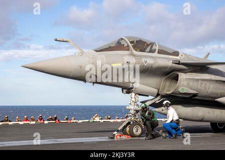 USS George HW Bush, Italien. 23.. November 2022. USA Marineteams bereiten einen französischen Kampfflugjet von Dassault Rafale vor, der vom Flugdeck des Flugzeugträgers USS George H.W. der Nimitz-Klasse gestartet werden soll Bush während des Betriebs mit mehreren Trägern am 23. November 2022 im Ionischen Meer. Kredit: MC3 Samuel Wagner/US Navy Photo/Alamy Live News Stockfoto