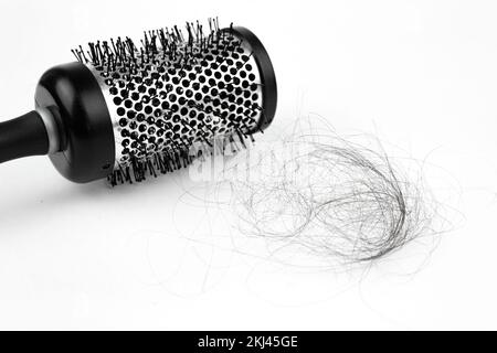 Runder Kammaufsatz mit Haarausfall. Schließen. Weißer Hintergrund. Haare fallen, Haarbürste mit Haaren Stockfoto
