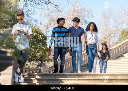Eine Gruppe junger Studenten, die auf einer Treppe laufen Stockfoto