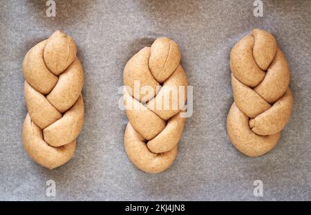 Zubereitung geflochtener Brötchen aus Vollkornspelzmehl - rohe Brötchen vor dem Backen, Draufsicht Stockfoto