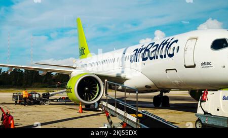 Kerkyra, Griechenland - 09 29 2022: Blick auf den Flughafen Korfu auf der grünen Ebene von AirBaltic. Parkplatz Für Flugzeuge, Flugzeuge Werden Vorher Mit Gepäck Beladen Stockfoto
