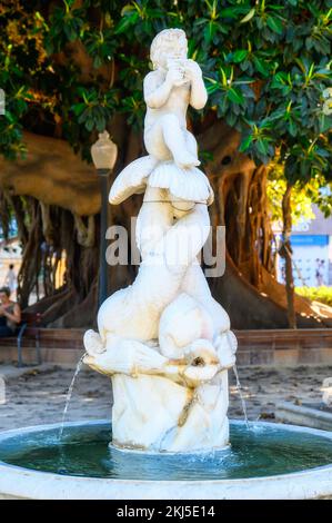 Alicante, Spanien - 12. September 2022: Ein kleiner Brunnen mit einer Skulptur im Canalejas Park. Die Skulptur besteht aus einem Flötisten, der auf dem Schwanz sitzt Stockfoto