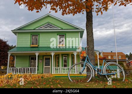 TADOUSSAC, QUEBEC, 13. Oktober 2022 : Ein schön eingerichtetes Holzhaus mit Garten und Fahrrad im touristischen Dorf Tadoussac. Stockfoto
