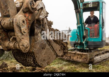 Nahaufnahme eines Baggers oder Grabers beim Graben von Erde oder Lehm, Industriekonzept Stockfoto