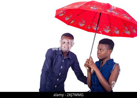 Porträt eines jungen Mannes und einer jungen Frau, die unter einem Schirm stehen. Stockfoto