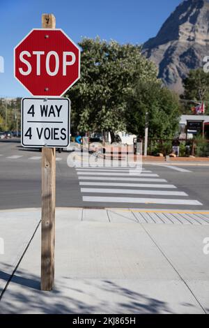 Stoppschild mit zweisprachigen Wörtern auf Englisch und Französisch, 4 Way und 4 voies, Waterton, Kanada Stockfoto