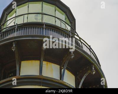 Nahaufnahme. Ein riesiger Turm eines hohen Leuchtturms vor einem bewölkten Himmel. Wunderschönes Gebäude, interessante Architektur. Baugewerbe, Infrastruktur, Tourismus, Stockfoto