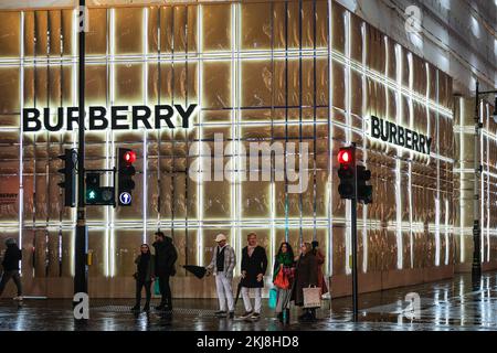 London, Großbritannien. 24.. November 2022. Der Burberry Store ist mit seinem berühmten Karomuster beleuchtet. Menschen in der Bond Street, Mayfair's berühmter Einkaufsstraße, und entlang Piccadilly stöbern durch die Schaufenster und bewundern die vielen bunten Ausstellungen und aufwändigen Weihnachtsdekorationen in den Luxusgeschäften von Mayfair. Kredit: Imageplotter/Alamy Live News Stockfoto