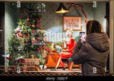 London, Großbritannien. 24.. November 2022. Einkaufslustige gehen vorbei und schauen sich hübsche dekorative Szenen in den Fenstern des Kaufhauses Fortnum & Mason an. Menschen in der Bond Street, Mayfair's berühmter Einkaufsstraße, und entlang Piccadilly stöbern durch die Schaufenster und bewundern die vielen bunten Ausstellungen und aufwändigen Weihnachtsdekorationen in den Luxusgeschäften von Mayfair. Kredit: Imageplotter/Alamy Live News Stockfoto