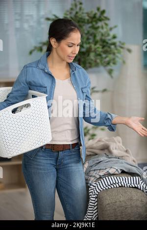 Die Frau weiß nicht, was sie tragen soll, wenn sie auf der Couch sitzt Stockfoto