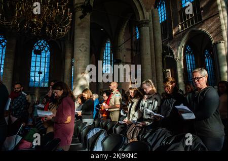 Leiden, Niederlande. 24.. November 2022. Während der Zeremonie werden Menschen die amerikanische Hymne singen sehen. Nachdem die Pilger England verließen, um der etablierten anglikanischen Kirche zu entkommen, und bevor sie auf Plymouth Rock landeten, kamen sie in Leiden an, den Niederlanden, wo sie 11 Jahre lang lebten. Thanksgiving hat eine besondere Bedeutung für die Holländer und jedes Jahr in Leiden ist der jährliche Thanksgiving Day Service im historischen Pieterskerk in Leiden eine Feier der Geschichte der Pilger und ihrer Verbindung zu Holland. Die Pilger dokumentierten ihre Geburten, Ehen und Todesfälle im Pieterskerk, Stockfoto