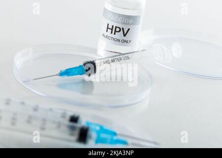 Zusammensetzung von hpv-Impfstofffläschchen und Spritzen auf weißem Hintergrund mit Kopierraum Stockfoto