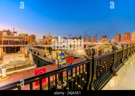 Doha, Katar - 17. Februar 2019: Luxuriöse Yachten und Boote, die bei Nacht an der Marina von Porto Arabia anlegen. Die Pearl-Qatar in Doha ist eine künstliche Insel Stockfoto