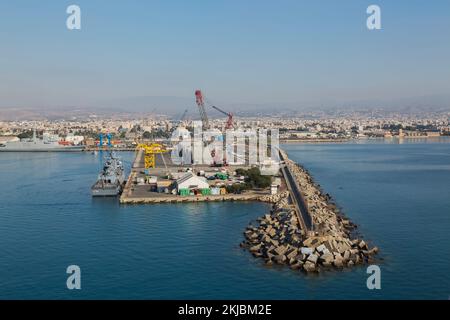 Angedocktes Kriegsschiff am Kai mit Portalkranen und künstlichem Wellenbrecher im Hafen von Limassol, Zypern. Stockfoto