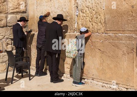 Jüdisch-orthodoxe Männer und Jungen beten an der Westwandtplatz oder Klagemauer, im jüdischen Viertel, in der Altstadt von Jerusalem, Israel. Stockfoto