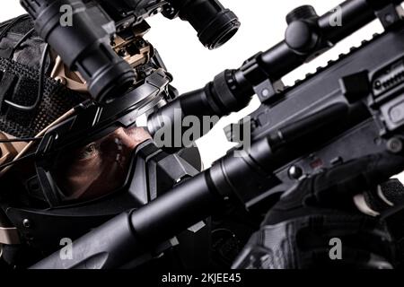 Ein Soldat mit taktischer Ausrüstung zielt mit Scharfschützengewehr auf den Feind. Abstraktes Gewehr und Gesicht mit Schutzmaske und Nachtsichtbrille. Stockfoto
