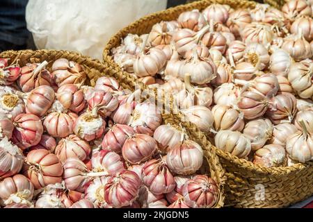 Korbkörbe mit geerntetem Knoblauch zum Verkauf auf einem marokkanischen Flohmarkt Stockfoto