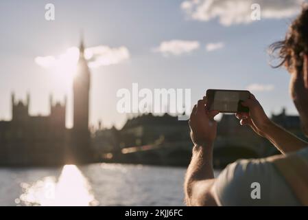 Ein Mann fotografiert Big Ben am Telefon in London, Reisen und Tourismus, Urlaubstouren und berühmtes historisches Wahrzeichen, Gebäude und Urlaub. Tourist Stockfoto