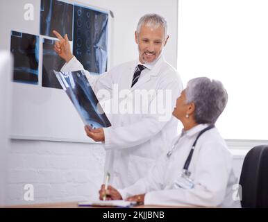 Rücksprache mit einem Kollegen für eine zweite Meinung. Zwei Ärzte arbeiten in einem Krankenhaus zusammen. Stockfoto