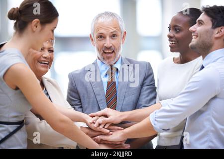 Ich freue mich darauf, ihr Team zu starten. Eine Gruppe von Geschäftsleuten, die ihre Hände in einer Einheit zusammenlegen. Stockfoto