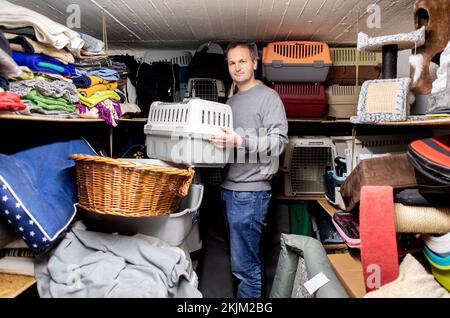 Bremen, Deutschland. 18.. November 2022. Stefan Evers, Vorsitzender der Bremer Tiertafel, steht in einem Raum mit Sachspenden, die die Tiertafel an bedürftige Haustierbesitzer ausgibt. Die Zahl der bedürftigen Haustierbesitzer und der Bedarf an Heimtierfutter und Sachspenden sind in diesem Jahr stark gestiegen. (An dpa: "Nachfragesteigerungen in Tiertafeln in Niedersachsen und Bremen") Kredit: Hauke-Christian Dittrich/dpa/Alamy Live News Stockfoto