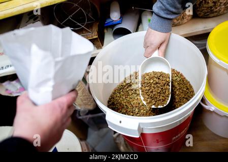 Bremen, Deutschland. 18.. November 2022. Tim Vieregge (l), Freiwilliger bei der Bremer Tiertafel, und Stefan Evers, Vorsitzender der Bremer Tiertafel, geben Trockenfutter in kleine Papiertüten. Die Zahl der bedürftigen Haustierbesitzer und der Bedarf an Heimtierfutter und Sachspenden sind in diesem Jahr stark gestiegen. (Dpa: "Die Nachfrage in Tiertafeln in Niedersachsen und Bremen steigt") Kredit: Hauke-Christian Dittrich/dpa/Alamy Live News Stockfoto