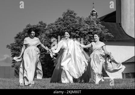 Ivano-Frankivsk, Ukraine 26. Juni 2021: Die Braut und ihre Freunde laufen barfuß auf dem Gras, Morgen der Braut mit ihren Freunden, Vorbereitung auf die Stockfoto