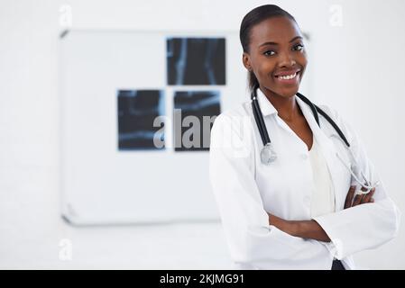 Sie ist ein erfolgreicher Radiologe. Eine Ärztin, die vor ein paar Röntgenaufnahmen steht. Stockfoto