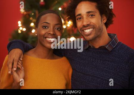 Wir feiern dieses Jahr gemeinsam Weihnachten. Gekürztes Porträt eines liebevollen jungen Paares zu Weihnachten. Stockfoto