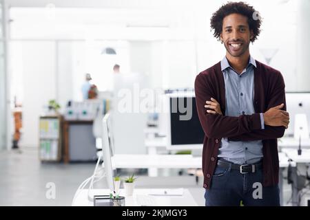 Ich freue mich, Teil des Teams zu sein. Porträt eines Geschäftsmannes, der mit gekreuzten Armen steht. Stockfoto