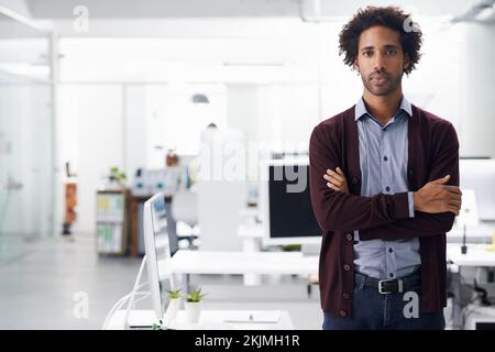 In diesem Büro ist das, was ich sage, erledigt. Porträt eines Geschäftsmannes, der mit gekreuzten Armen steht. Stockfoto