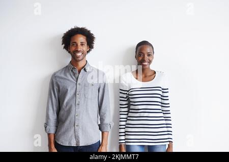 Mann und Frau. Ein Porträt eines glücklichen jungen Paares, das zusammen an einer weißen Wand steht. Stockfoto