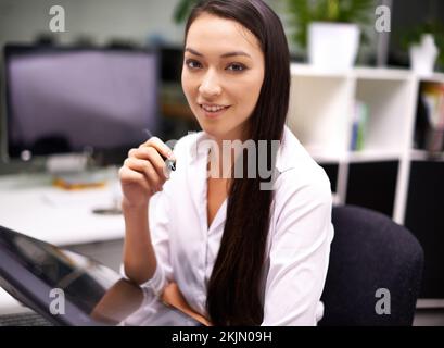 Technologie macht die Arbeit Spaß. Porträt einer attraktiven jungen Geschäftsfrau, die an ihrem Schreibtisch arbeitet. Stockfoto