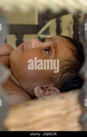 A Frame with Frame Aufnahme eines süßen indischen Babys, das von der Kamera wegschaut. Selektiver Fokus auf das Auge, während andere verschwommen sind. Stockfoto