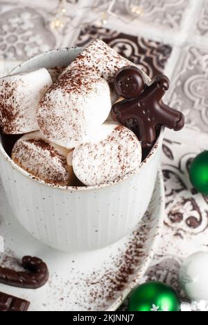 Heißgetränketasse mit Marshmallow und Schokoladen-Lebkuchenmann. Weihnachtskreationen. Stockfoto