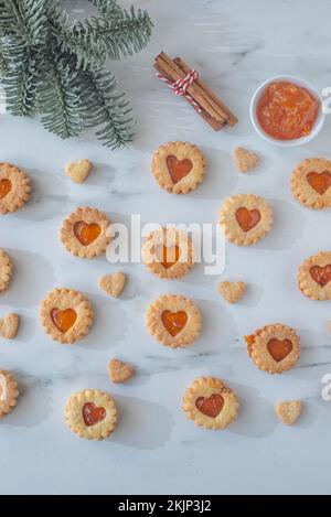 Süße hausgemachte linzer weihnachtskekse gefüllt mit Aprikosenmarmelade auf einem Tisch Stockfoto