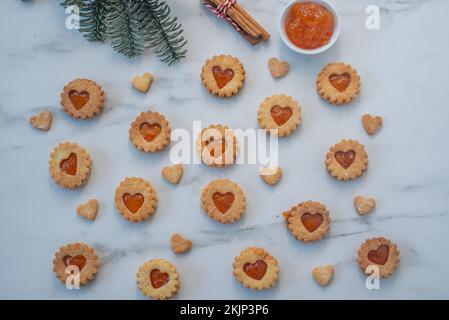 Süße hausgemachte linzer weihnachtskekse gefüllt mit Aprikosenmarmelade auf einem Tisch Stockfoto