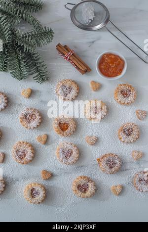 Süße hausgemachte linzer weihnachtskekse gefüllt mit Aprikosenmarmelade auf einem Tisch Stockfoto