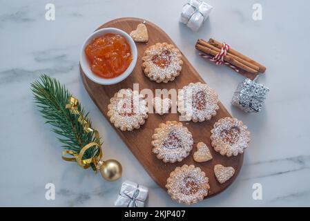 Süße hausgemachte linzer weihnachtskekse gefüllt mit Aprikosenmarmelade auf einem Tisch Stockfoto