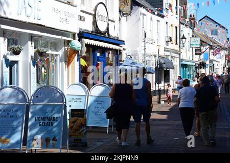 Blick auf Shoppers und Shops entlang der Old Fore Street im Stadtzentrum, Sidmouth, Devon, Großbritannien, Europa. Stockfoto