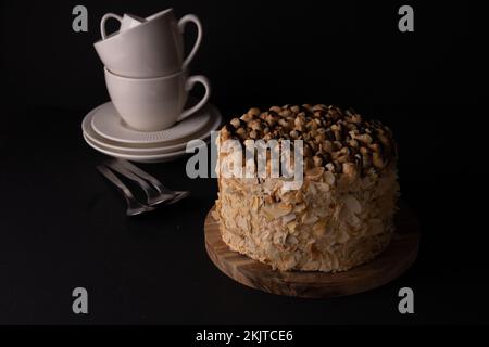 Foto: Walnusskuchen mit weißen Gerichten auf schwarzem Hintergrund, Draufsicht Stockfoto