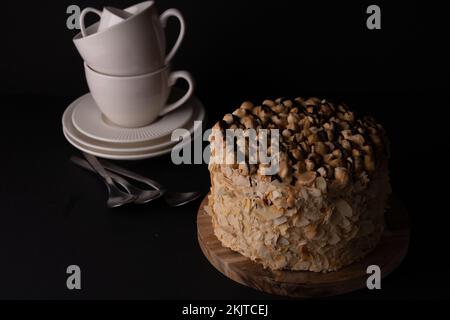 Foto: Walnusskuchen mit weißen Gerichten auf schwarzem Hintergrund, Draufsicht Stockfoto