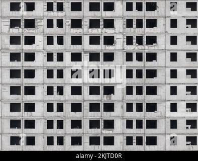 Nahtloses Hintergrundbild einer Betonwand mit leeren Fenstern. Ein neuer Wohnblock befindet sich im Bau Stockfoto