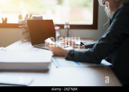 Buchhalter, asiatische Wirtschaftsprüfer verwenden Rechner und Computer, um die jährlichen Steuerbudgets zu überprüfen, um Informationen an das IRS zu übermitteln. Stockfoto