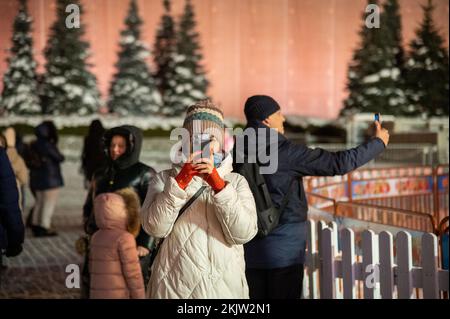 Moskau, Russland - 7. Januar 2022: Mädchen macht Fotos auf einem Smartphone auf dem Roten Platz in der Nähe des Kremls. Stockfoto